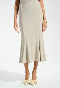 Woman wearing a beige skirt and matching shoes on a white background