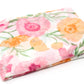 Floral-patterned blanket with pink, orange, and green flowers on a white background