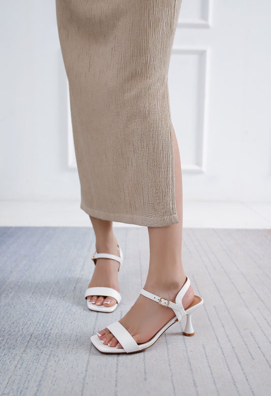 Person wearing white sandals with a blurred background