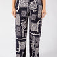 Person wearing black and white patterned pants on a white background
