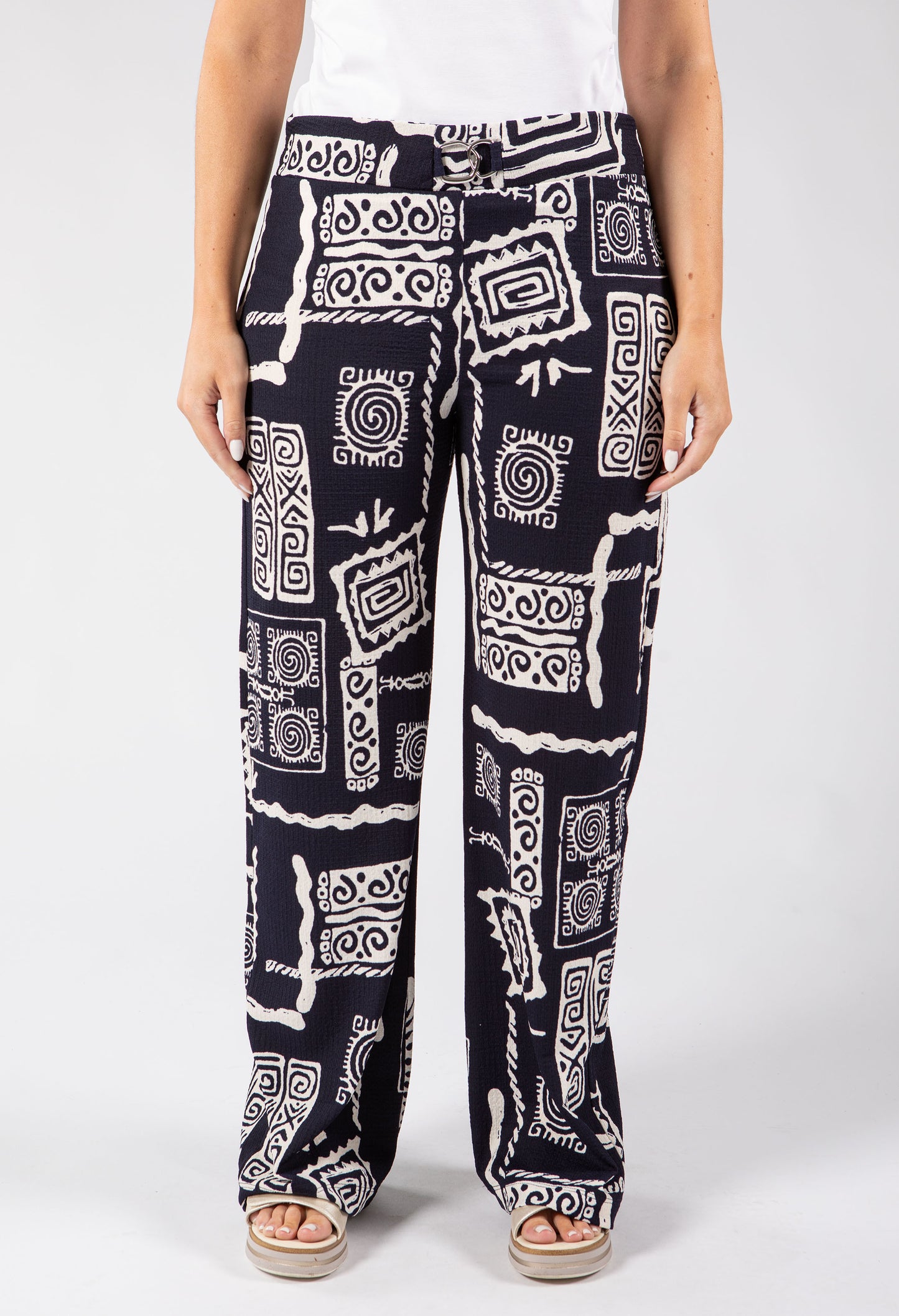 Person wearing black and white patterned pants on a white background