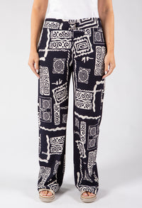 Person wearing black and white patterned pants on a white background
