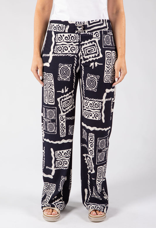 Person wearing black and white patterned pants on a white background