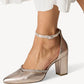 Metallic high-heeled shoe with a subtle pattern on a white background