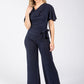 Woman wearing a navy jumpsuit on a white background