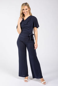 Woman wearing a navy jumpsuit on a white background