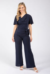 Woman wearing a navy blue jumpsuit on a white background