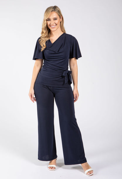 Woman wearing a navy blue jumpsuit on a white background