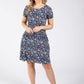 Woman wearing a navy floral dress on a white background
