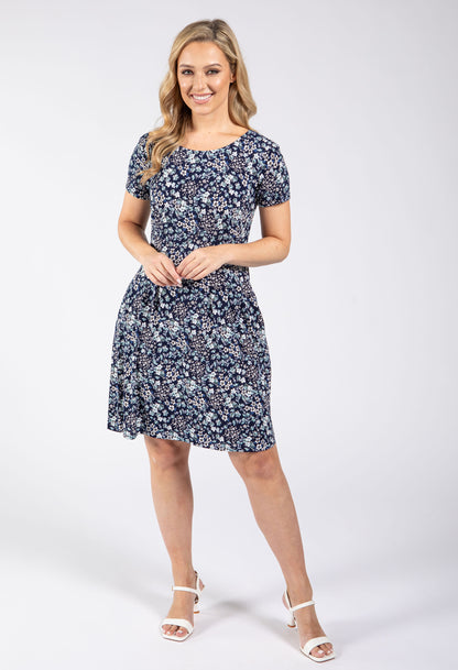 Woman wearing a navy floral dress on a white background