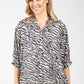 Woman wearing a zebra print blouse on a white background