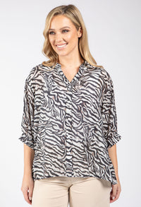 Woman wearing a zebra print blouse on a white background
