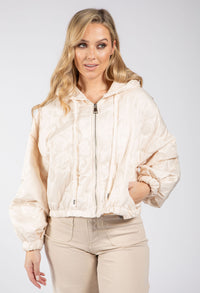 Woman wearing a beige quilted jacket on a white background