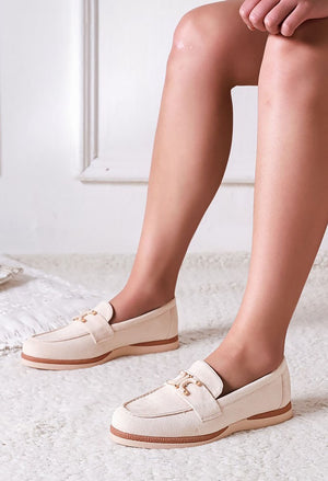 White loafers worn by a person on a light background
