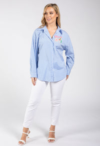 Woman wearing a blue striped shirt with a colorful design on a white background