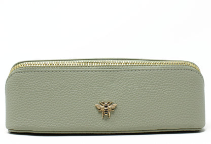 Light green make up bag with a gold zipper and bee emblem on a white background
