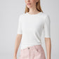woman wearing a ribbed white top with half length sleeves