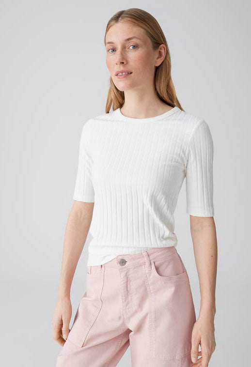 woman wearing a ribbed white top with half length sleeves