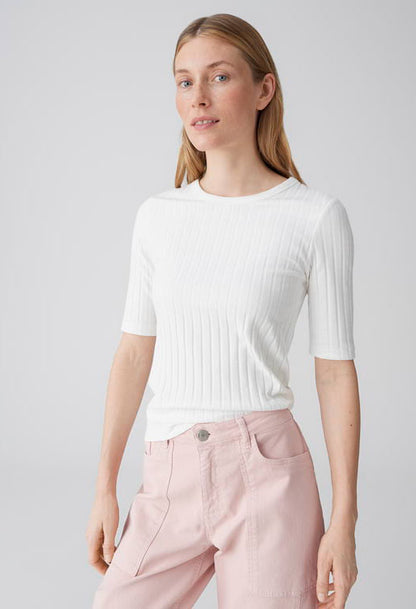 woman wearing a ribbed white top with half length sleeves