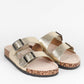 Pair of gold sandals with cork soles on a white background