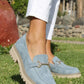 Blue suede loafers worn outdoors on a grassy area