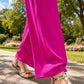 Person wearing bright pink pants and colorful sandals on a sunny day outdoors.