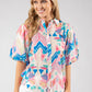 Woman wearing a colorful patterned blouse on a white background