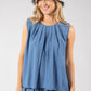 Woman wearing a blue sleeveless top and skirt with a matching denim hat on a white background