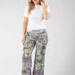 Woman wearing a white t-shirt and colorful patterned pants on a white background