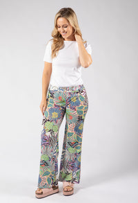 Woman wearing a white t-shirt and colorful patterned pants on a white background